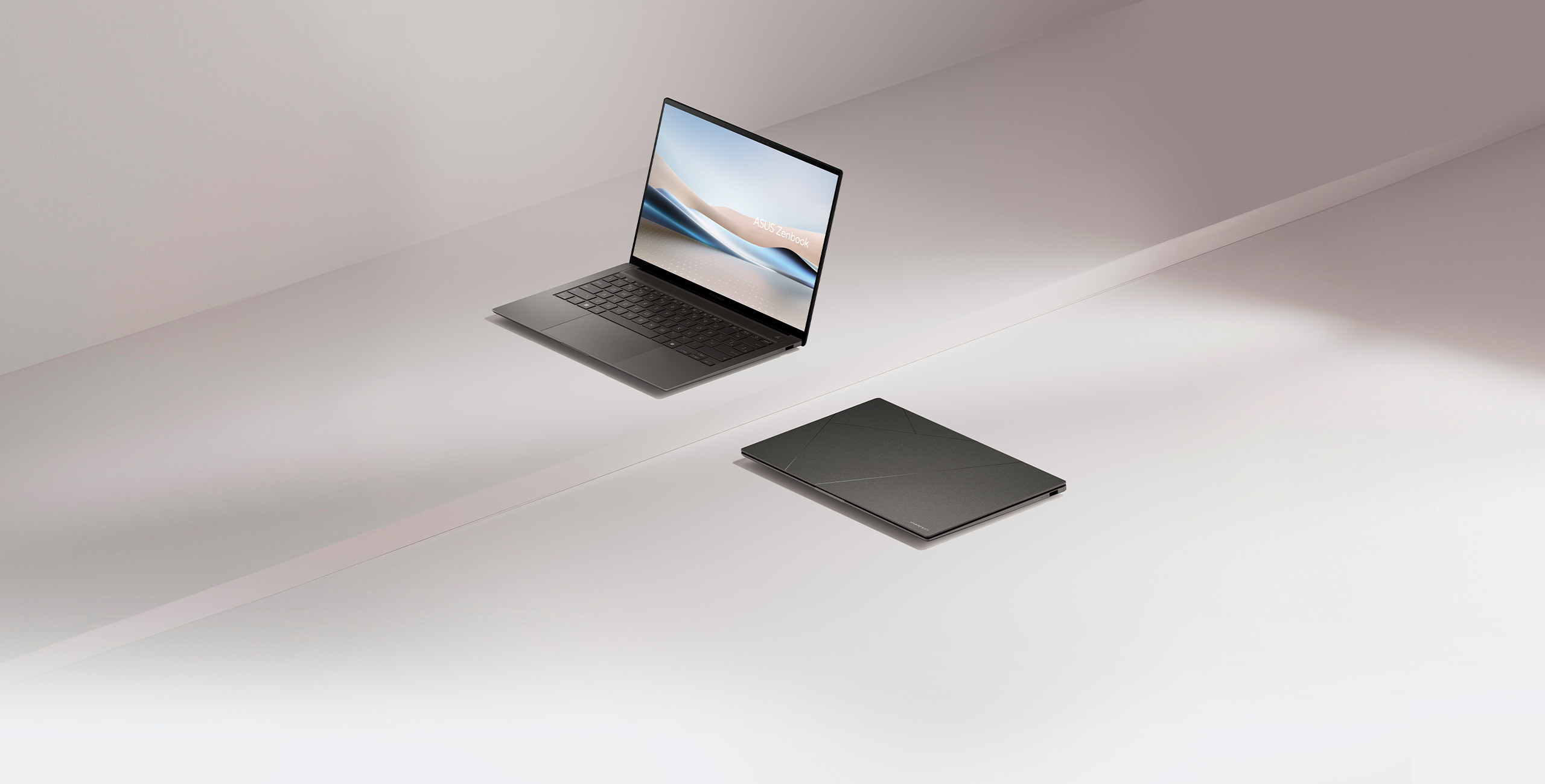 Two Zenbook S 14, one of them opened at 100 degrees and viewed from the left front, while the other one is closed and placed on the ground.