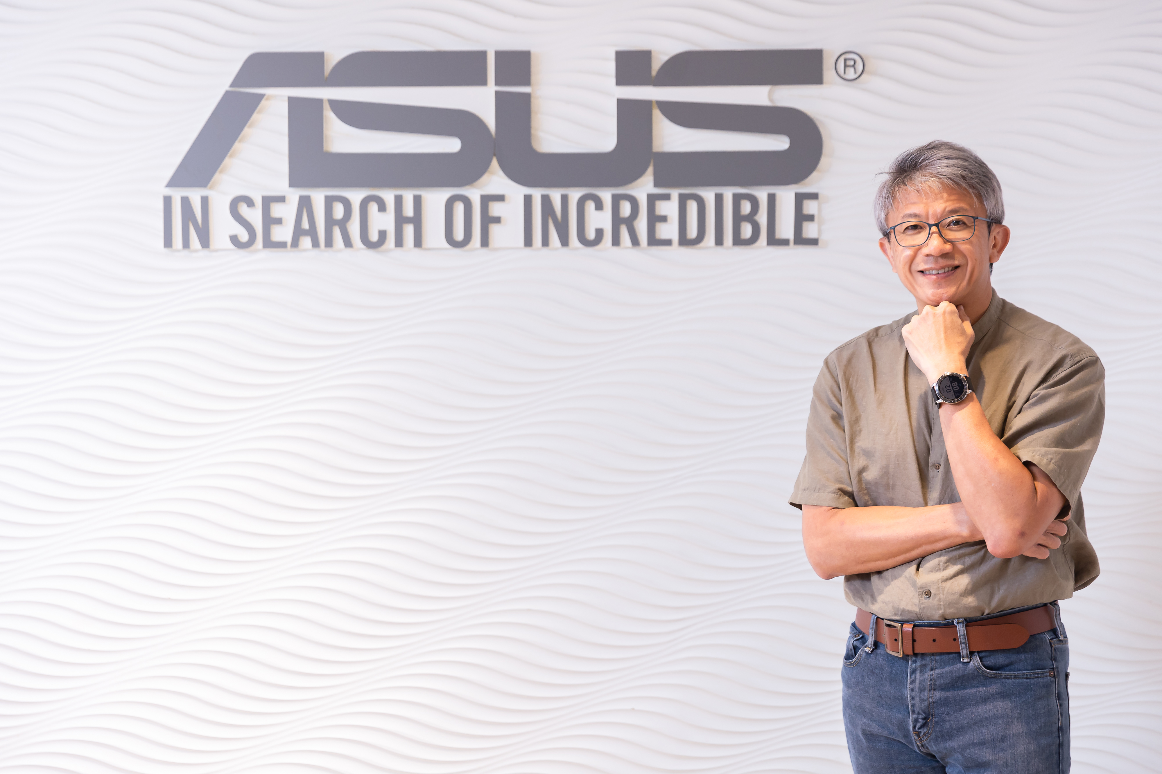 ASUS COO and SVP Joe Hsieh is wearing VivoWatch and standing in front of ASUS logo wall to present the watch in confidence 