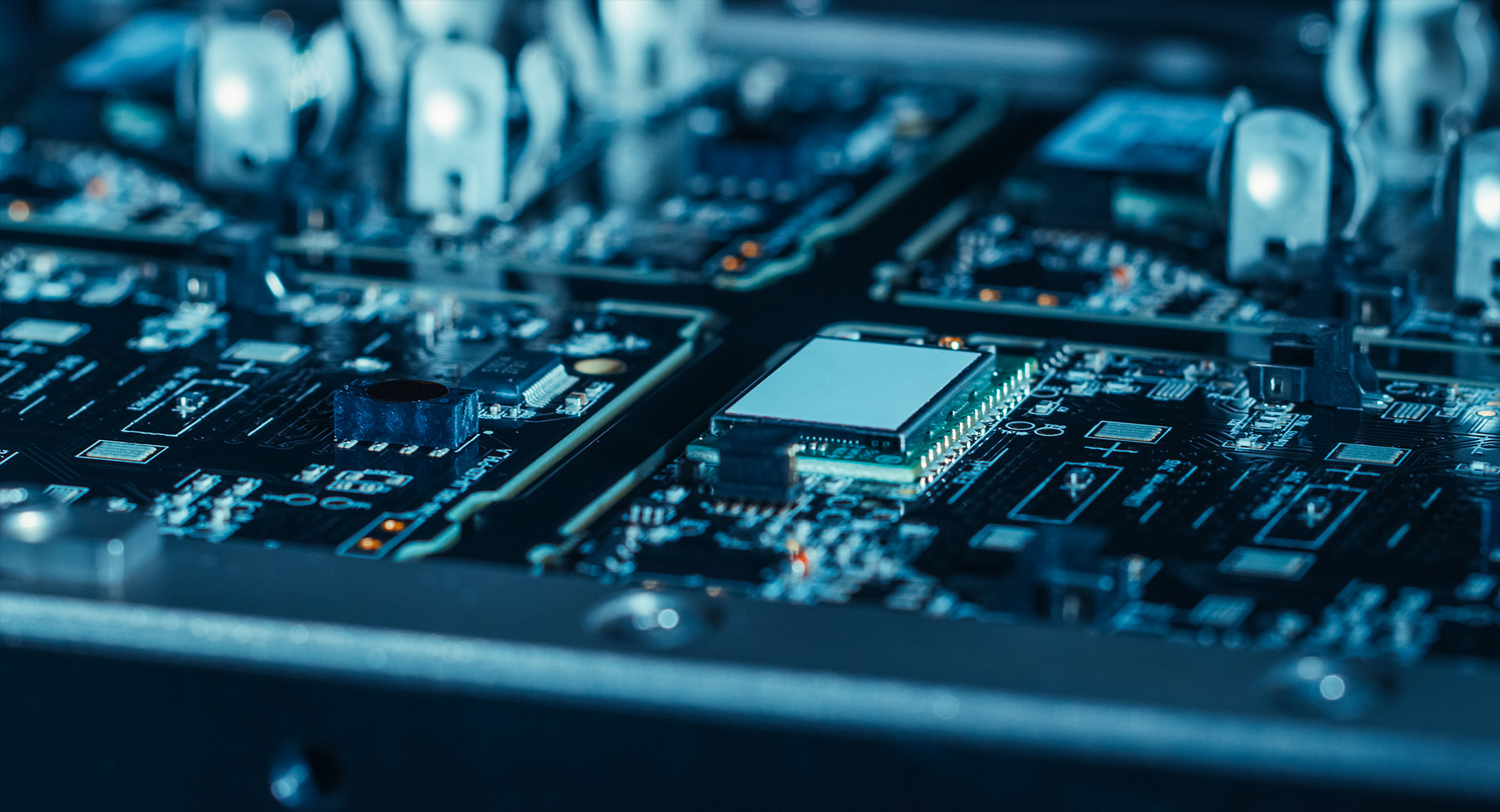 Macro shot of a robotic arm assembling a PCB using surface-mount technology (SMT) to connect microchips to the motherboard.