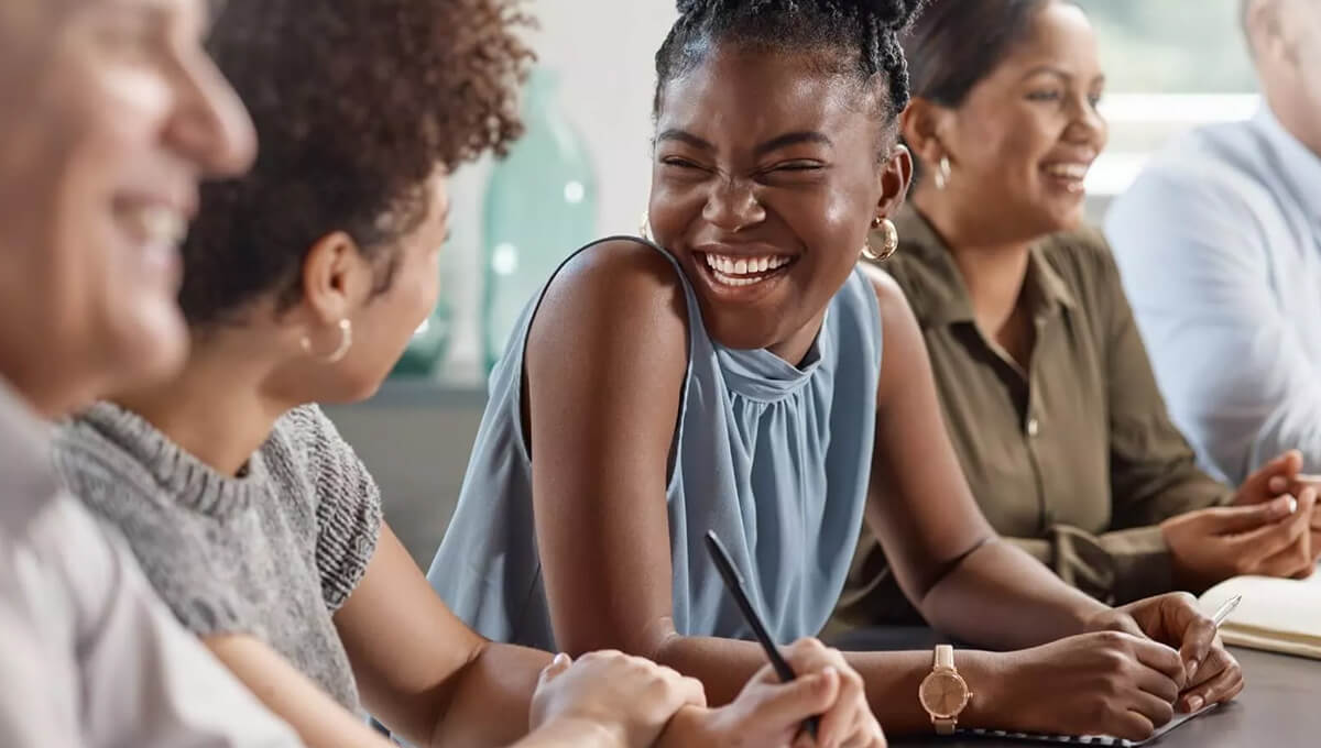 A young woman smiles while looking at a person in a diverse group of people