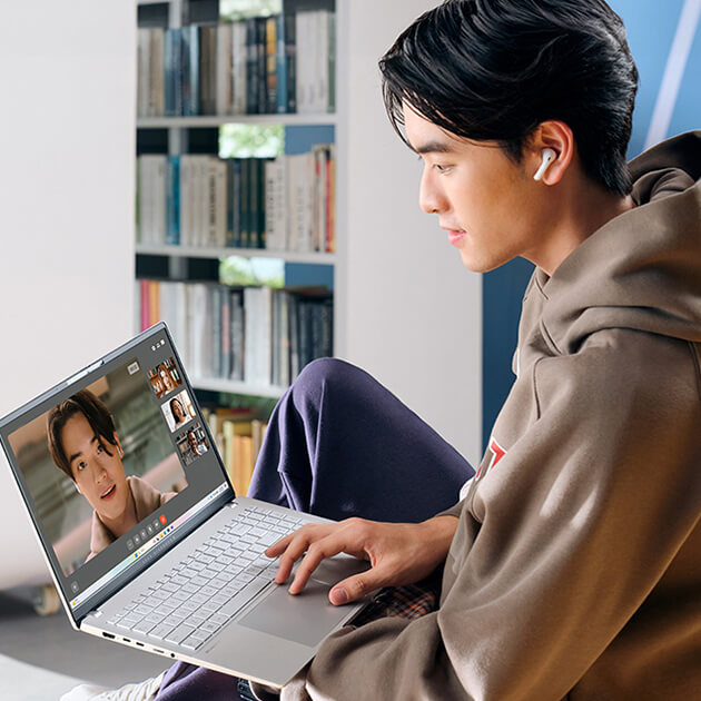 A young man uses ASUS Vivobook S 15 laptop for videoconferencing.