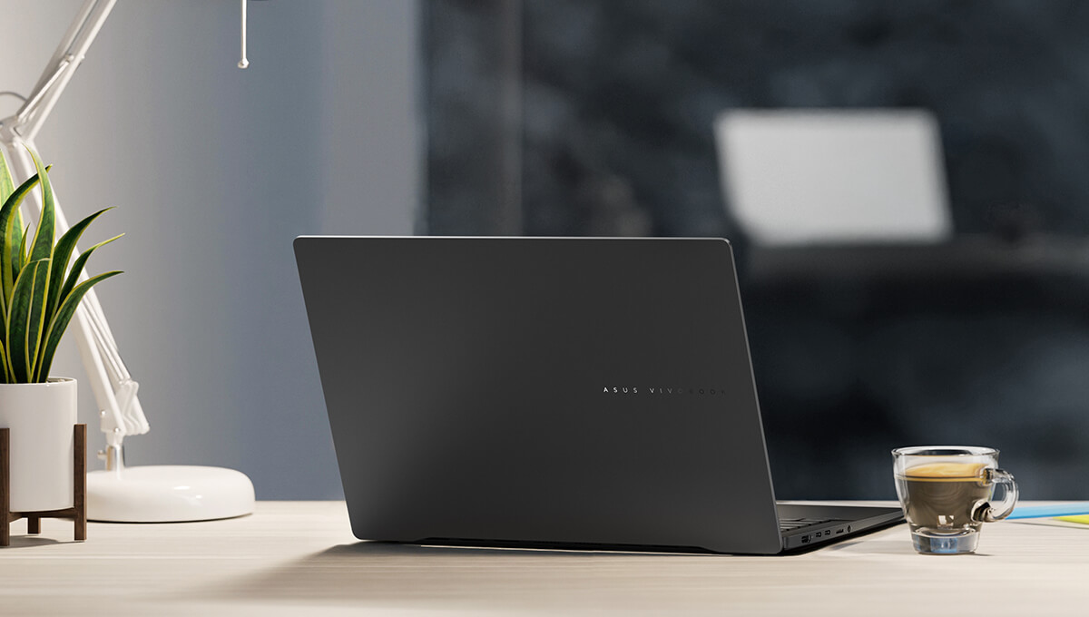 An ASUS Vivobook S 14 laptop on a desk, with a cup of coffee next to it