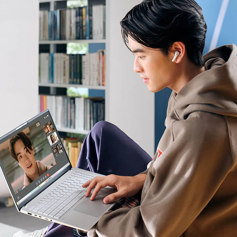 A young man uses ASUS Vivobook S 15 laptop for videoconferencing.